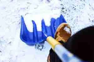 Foto gratuita uomo lavoratore in uniforme, spalare la neve. immagine ravvicinata