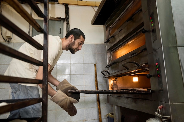 Free photo man working in a bread bakery