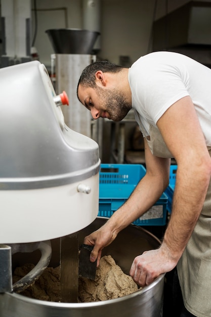 Free photo man working in a bread factory