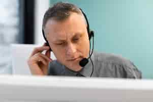 Free photo man working in a call center with headphones and computer