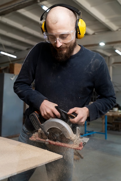 Free photo man working on cutting mdf board