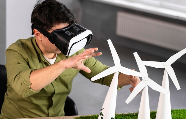 Uomo che lavora a un progetto di energia eolica ecologico utilizzando le cuffie da realtà virtuale