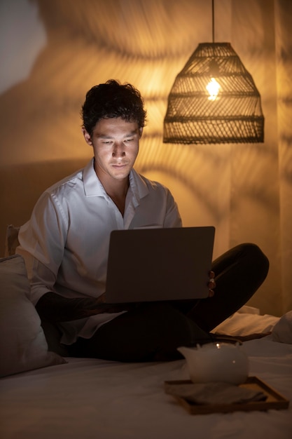 Man working from home with laptop full shot