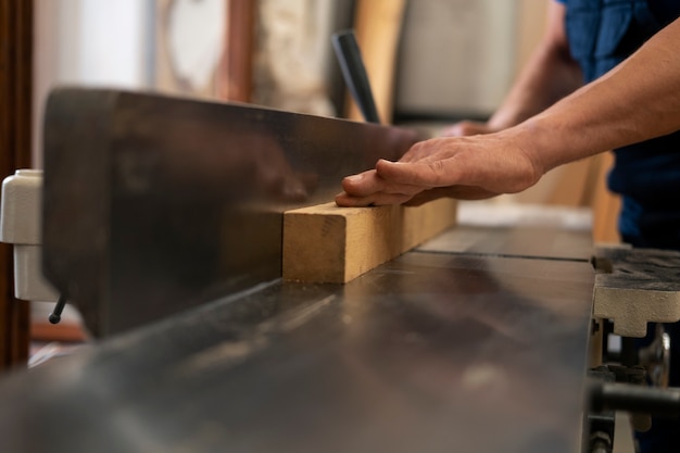 Free photo man working in his wood shop with tools and equipment