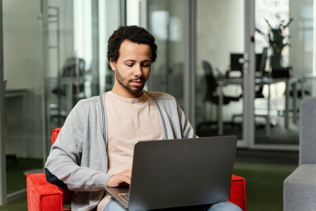 会社でラップトップに取り組んでいる男