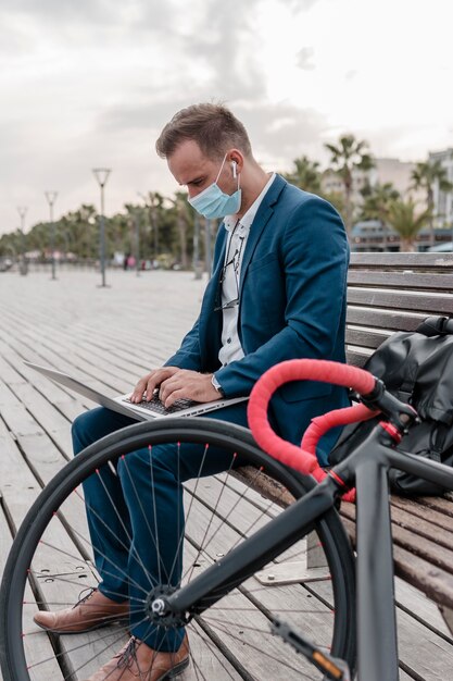 Man working on a laptop next to his bike