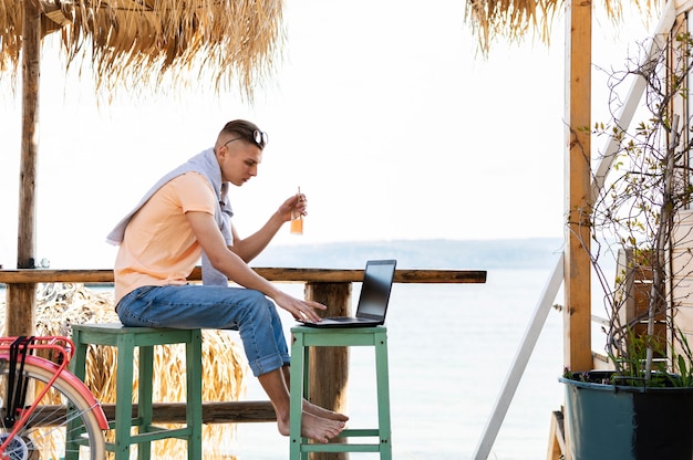 Man working on laptop outside full shot