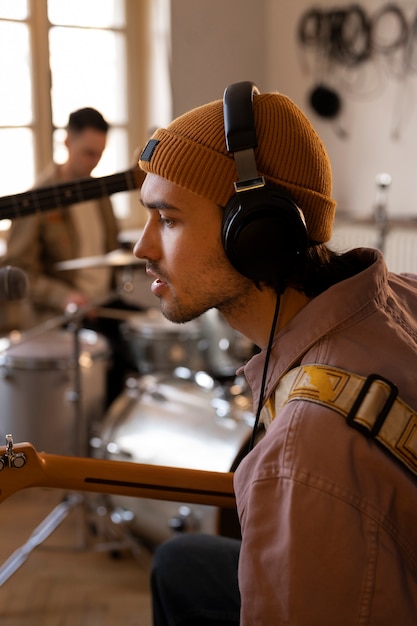 Foto gratuita uomo che lavora alla musica in studio con strumenti