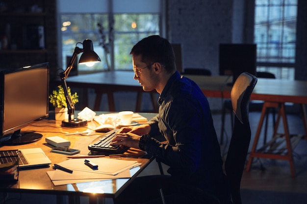 Free photo man working in office alone