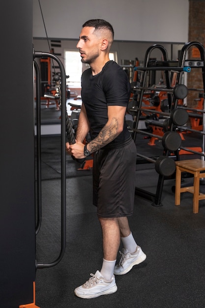 Бесплатное фото Мужчина тренируется в спортзале на полную катушку