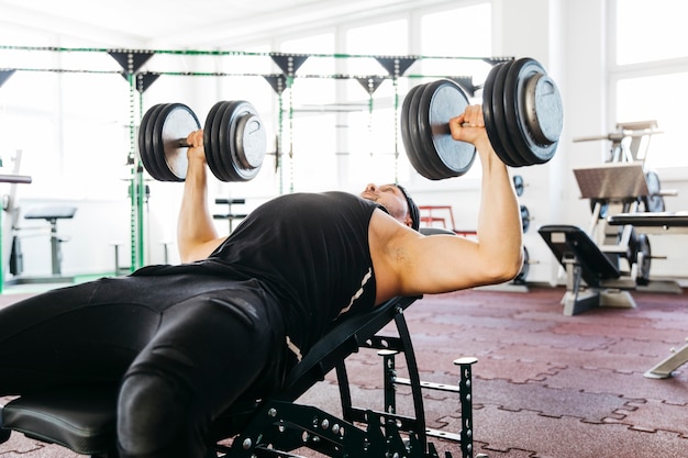 Foto gratuita uomo che lavora in palestra