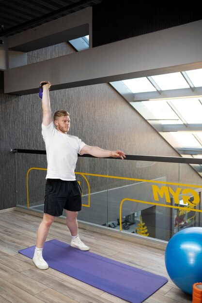 Man working out with kettlebell full shot