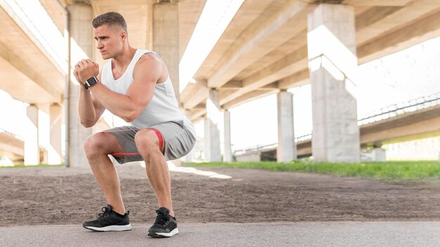 Man working out with a stretching band with copy space