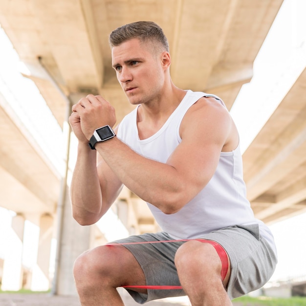 Foto gratuita uomo che lavora con una fascia di stretching