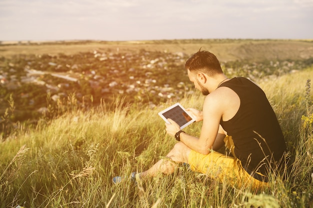 Man working outdoors with tablet pad. Retro vintage instagram filter