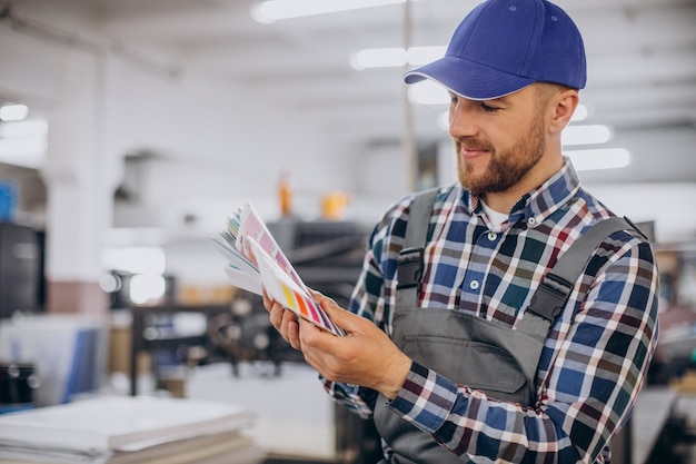 Man working in printing house with paper and paints