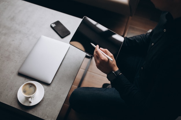 Man working on tablet close up at the table