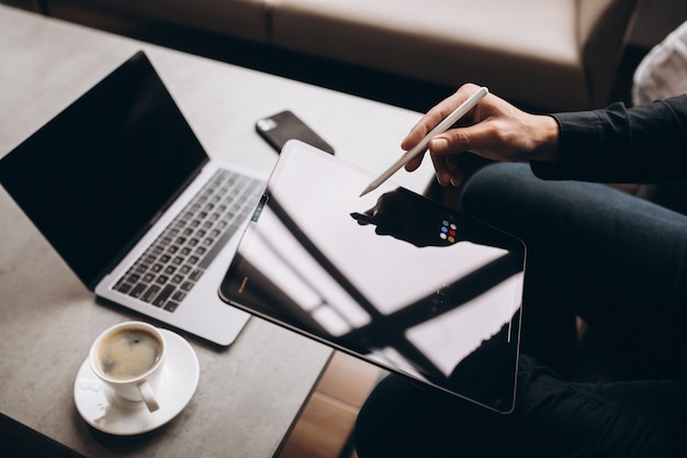 Man working on tablet close up at the table