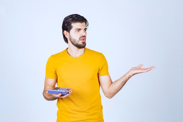 Man working with calculator and looks dissatisfied.