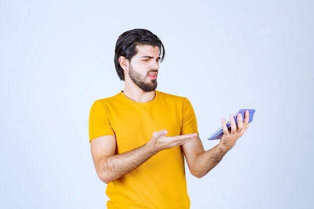 Man working with calculator and looks dissatisfied.