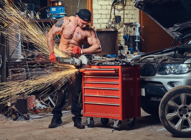 Foto gratuita un uomo che lavora con una sega circolare a mano in un garage.