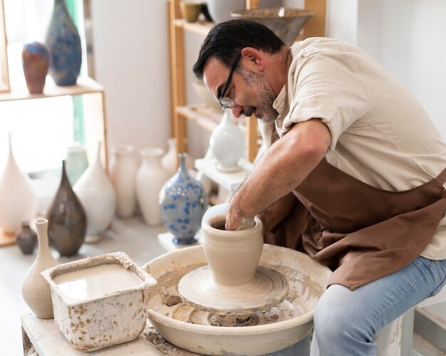 Man working with clay medium shot