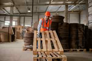 Free photo man working with heavy wooden materials