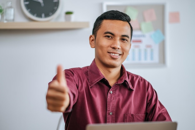 Man working with laptop with thumbs up