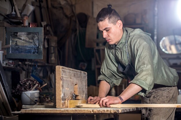 Man working with wooden product on the machine