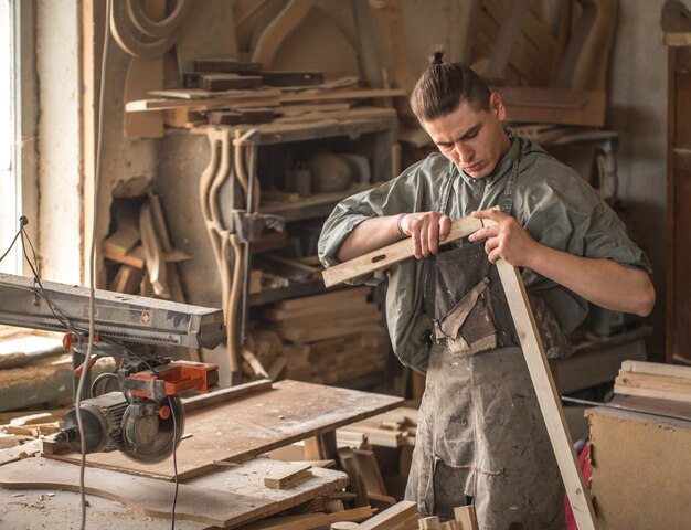 Man working with wooden product on the machine