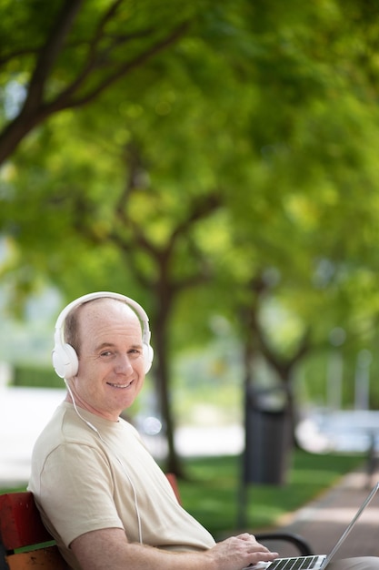 A man works on a laptop in the park