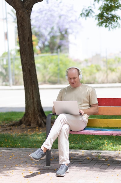 A man works on a laptop in the park