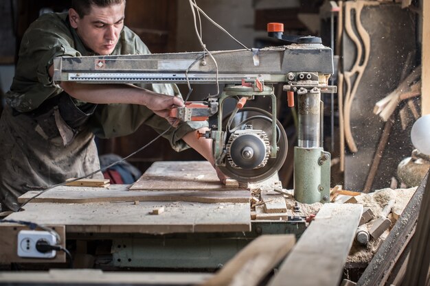 man works on the machine with the wooden product