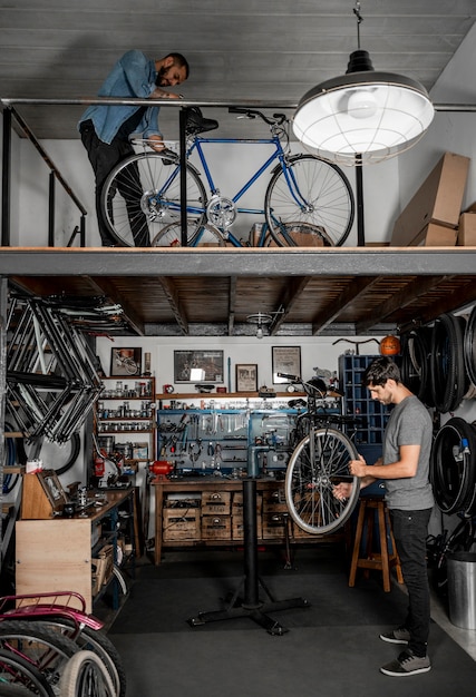 Человек в мастерской, создавая велосипед