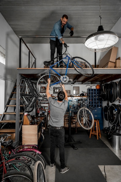 Человек в мастерской, создавая велосипед