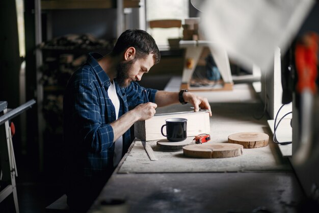 Man in the workshop with a wood