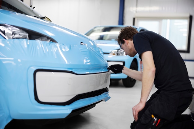 Man wrapping car inside full shot