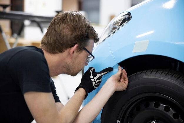 Man wrapping car with blue cover medium shot