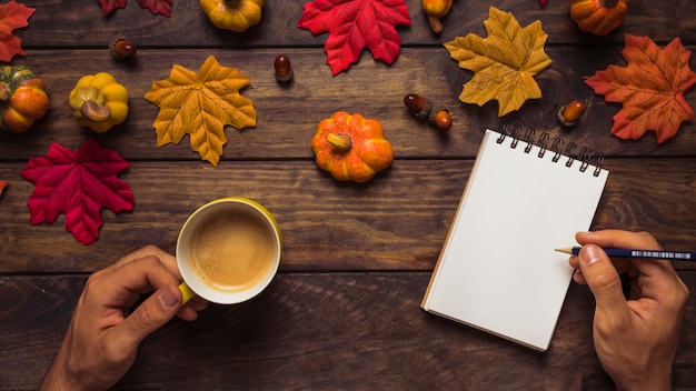 Man writing at autumn decorated workplace