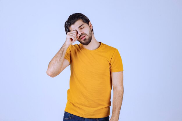 Man in yellow shirt looks sleepy