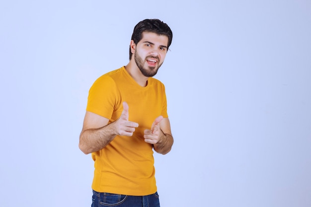 Man in yellow shirt pointing to someone ahead.