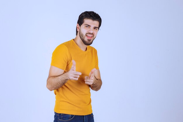 Man in yellow shirt pointing to someone ahead.