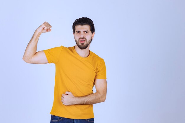 Man in yellow shirt showing his fist and power.