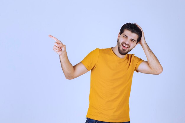 Man in yellow shirt showing something on the left.