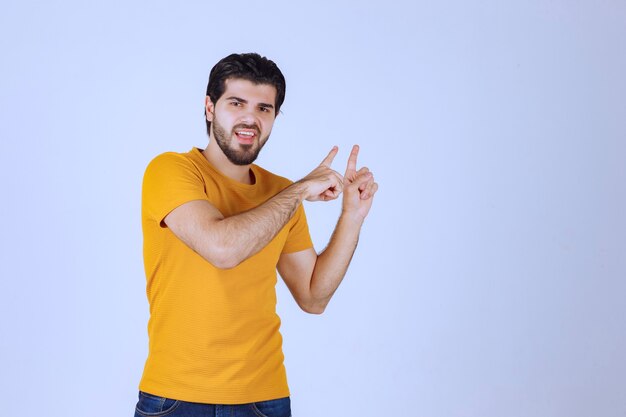 Man in yellow shirt showing something above.