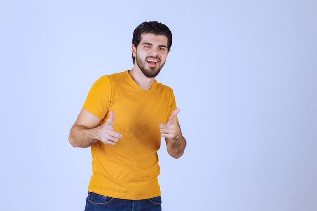 Man in yellow shirt showing thumb up.