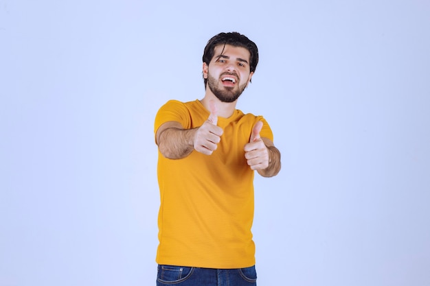 Man in yellow shirt showing thumb up