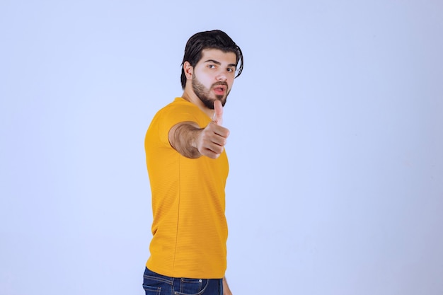 Man in yellow shirt showing thumb up