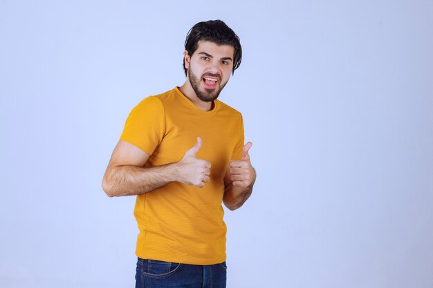 Man in yellow shirt showing thumb up