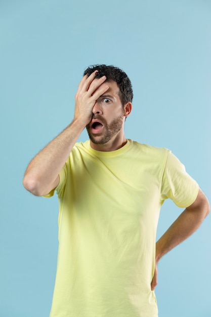 Man in yellow t-shirt posing for a studio portrait